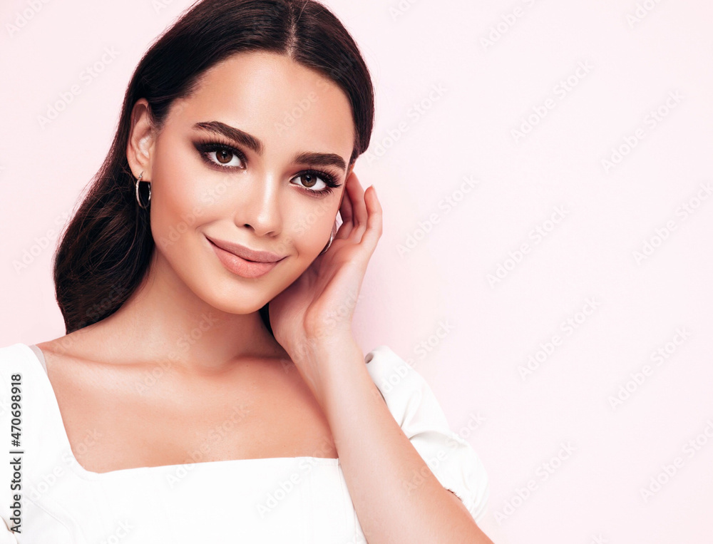 Fashion beauty portrait of young brunette woman with natural stylish makeup and perfect clean skin. Sexy model with long curly hair posing in studio on pink background Fashion beauty portrait of young brunette woman with natural stylish makeup and perfect clean skin. Sexy model with long curly hair posing in studio on pink background