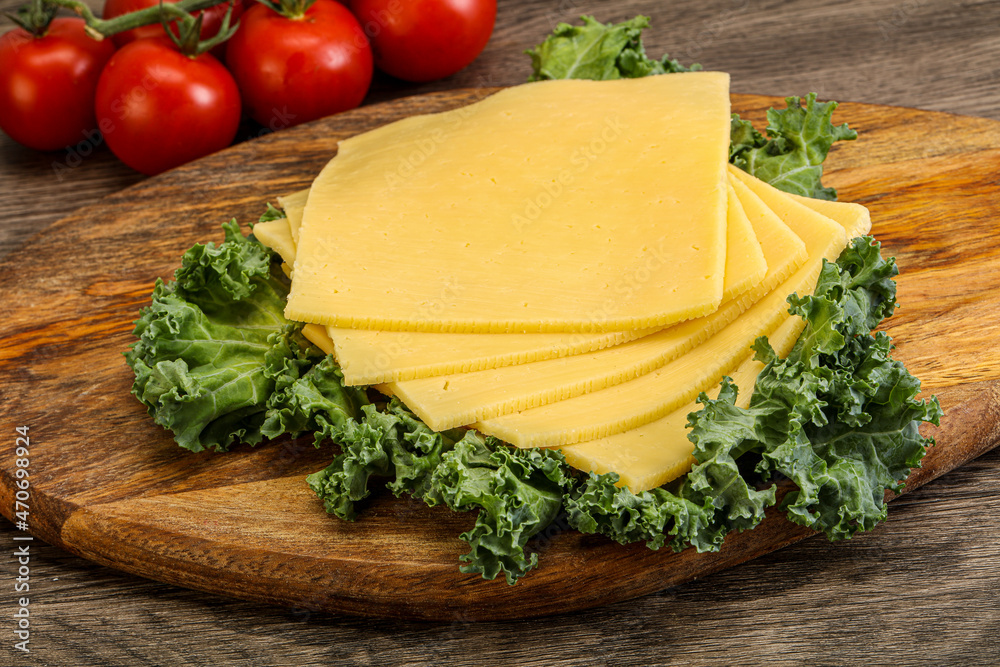 Sliced Gauda cheese over board Sliced Gauda cheese over board