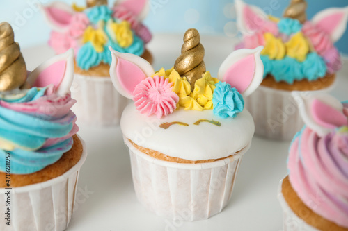 Cute sweet unicorn cupcakes on white table  closeup
