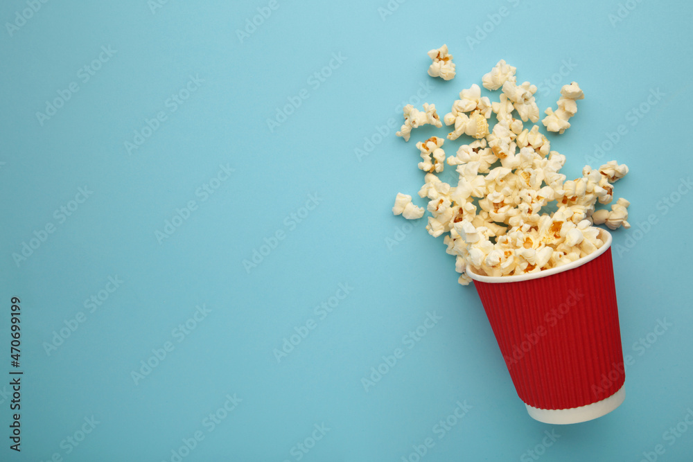 Delicious popcorn on light blue background. Space for text