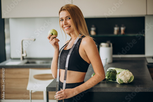 Young woman with measuting tape at the kitchen photo