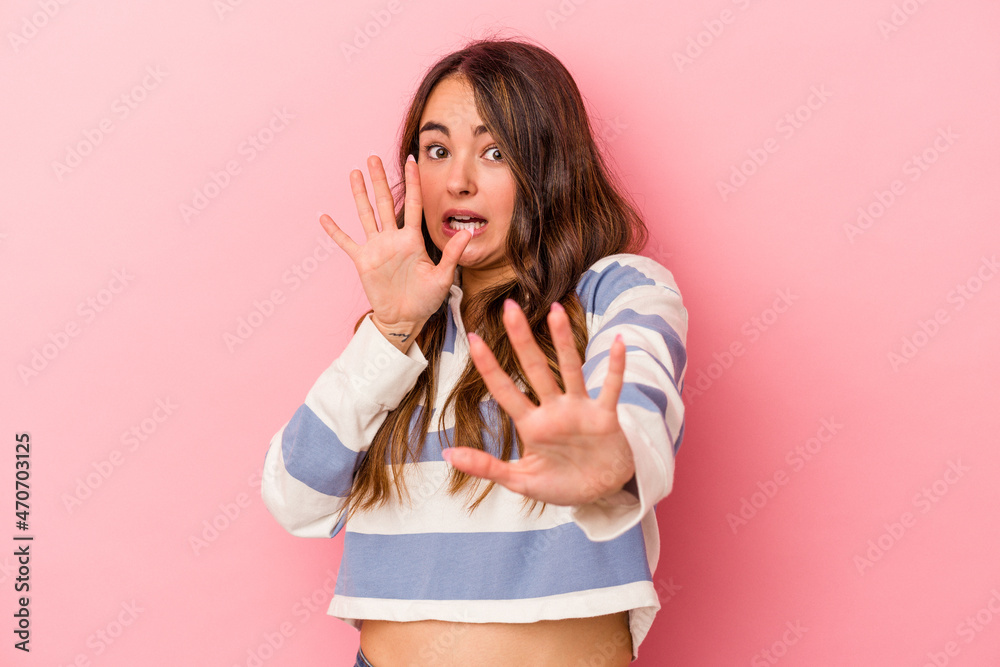 Young caucasian woman isolated on pink background being shocked due to an imminent danger Young caucasian woman isolated on pink background being shocked due to an imminent danger