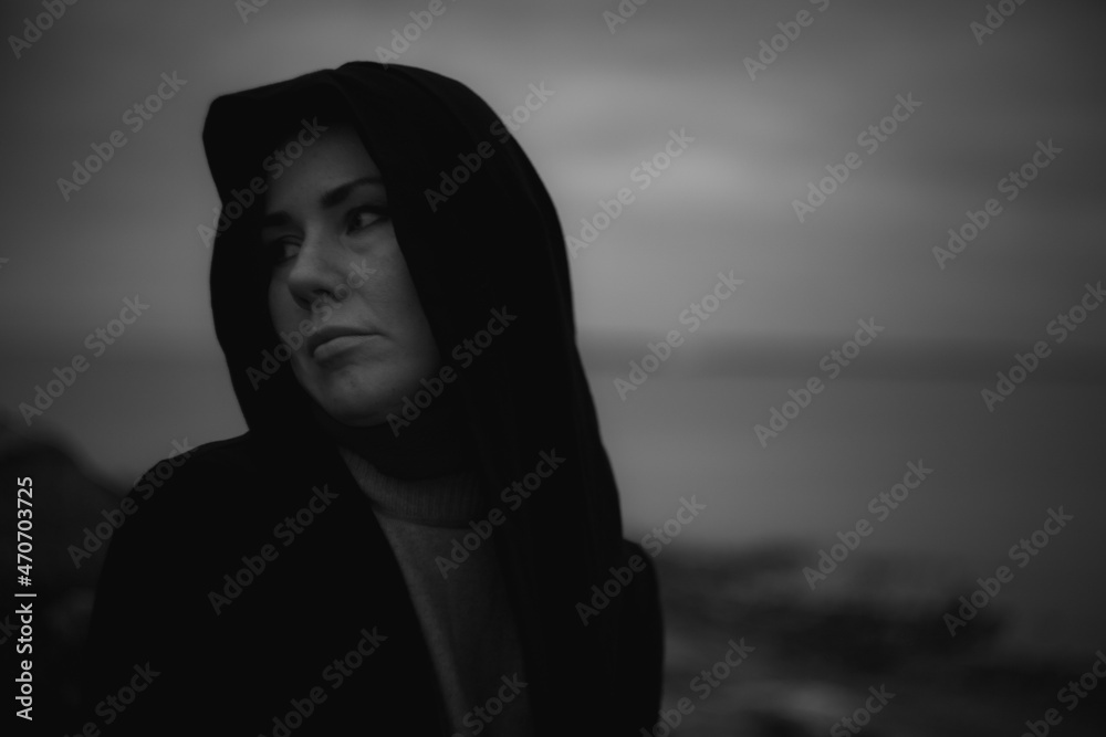 Sad woman sitting on stones by the lake Sad woman sitting on stones by the lake