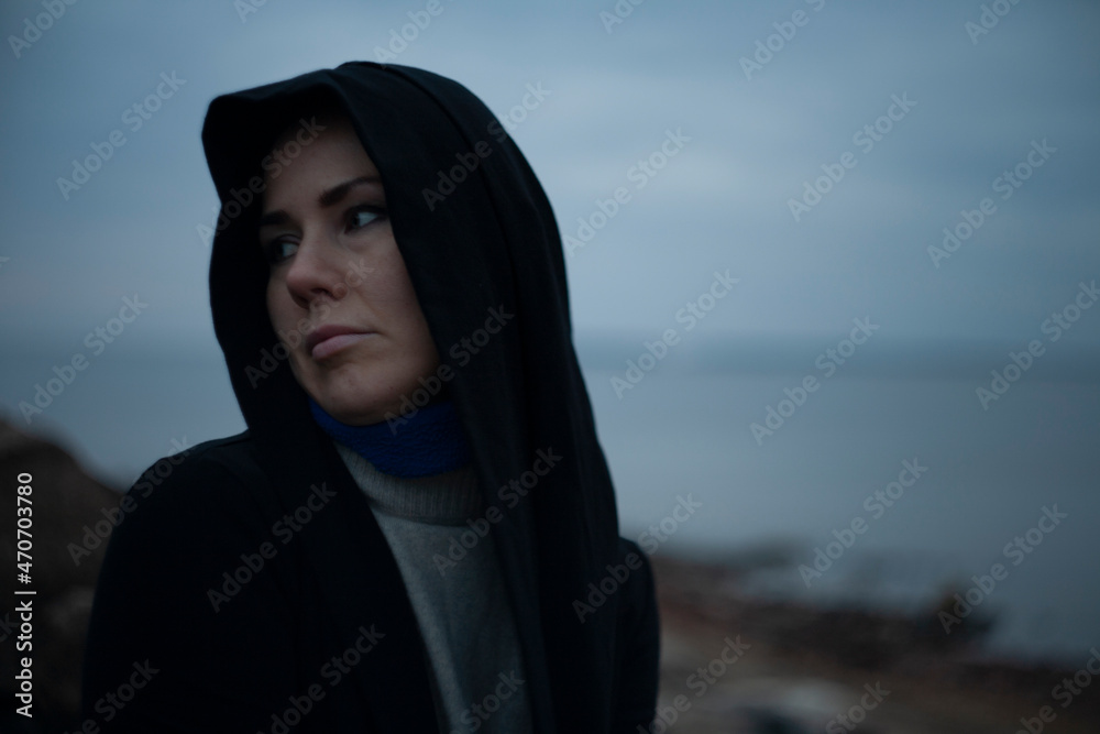 Sad woman sitting on stones by the lake Sad woman sitting on stones by the lake