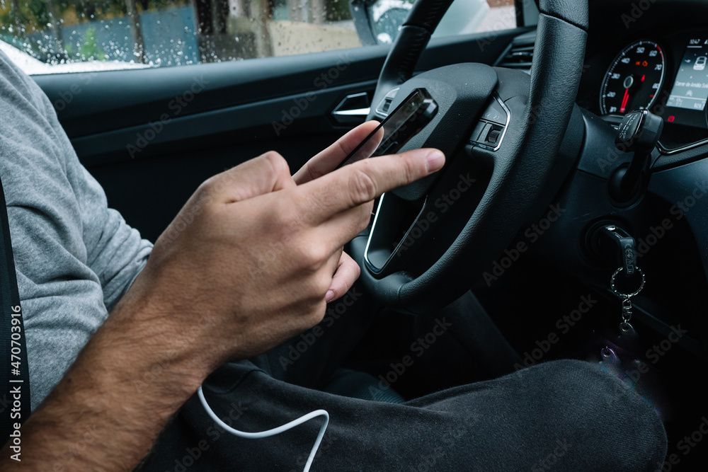 person using the phone while driving a car