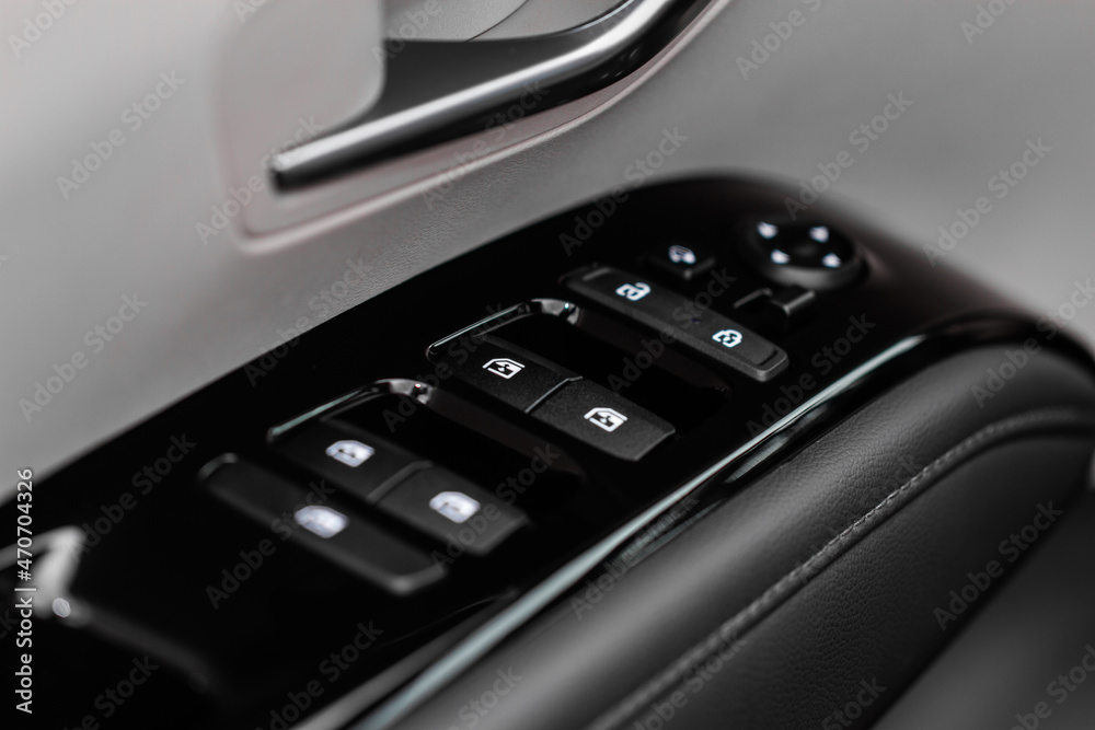 Close up view of button controlling window in modern car interior. Vehicle interior detail. Door handle with windows controls Close up view of button controlling window in modern car interior. Vehicle interior detail. Door handle with windows controls