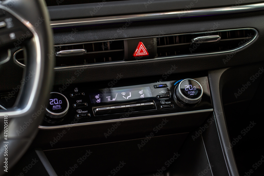 Red triangle hazard light button on car dashboard. Car media buttons dashboard. Detail of a modern car controllers.