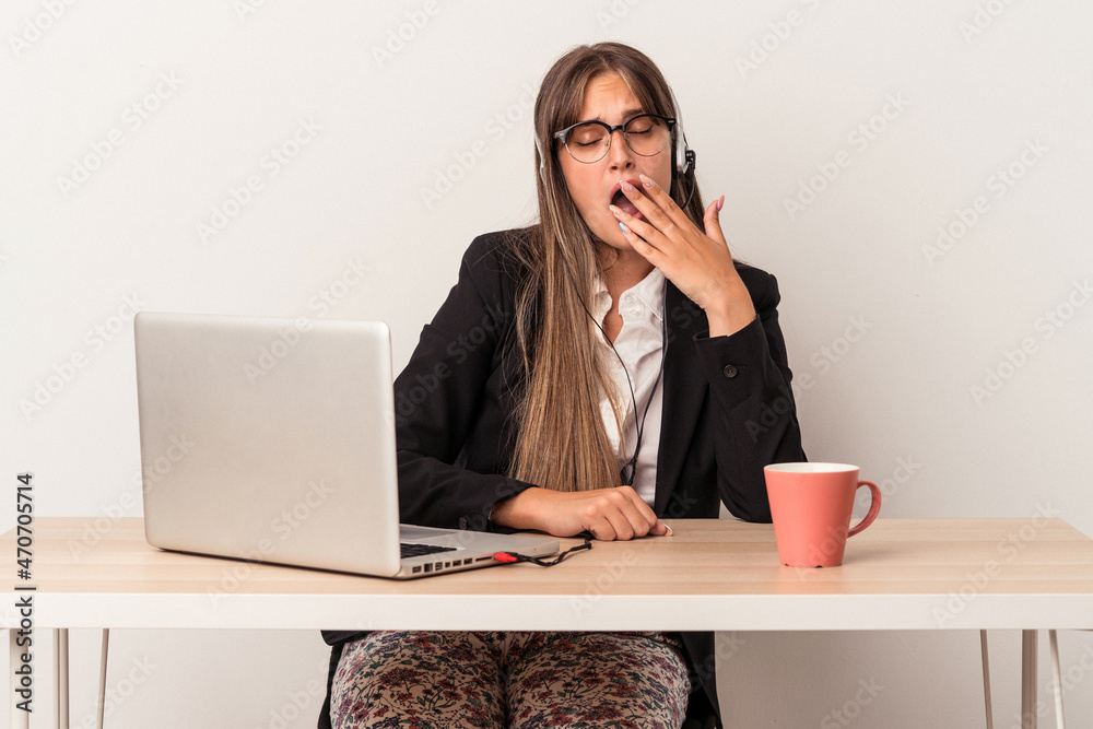 Young caucasian woman doing telecommuting isolated on white background yawning showing a tired gesture covering mouth with hand. Young caucasian woman doing telecommuting isolated on white background yawning showing a tired gesture covering mouth with hand.