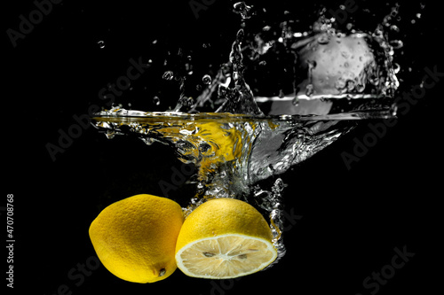Lemon falling into water creating movement, motion and splashes