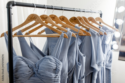 Blue bridesmaids dresses used for a wedding hanging on the hanger A few beautiful wedding dresses on a hanger Clothes for bridesmaids dresses hanging on trempel Close-up of the bridesmaids' dresses photo