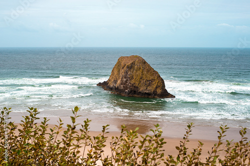 A peaceful Oregon beach coastline with Jockey Cap Rock in the middle, crashing ocean waves. Nature Landscape Background. Island near Tolovana Park, Cannon Beach, and Silver Point in Clatsop County. photo