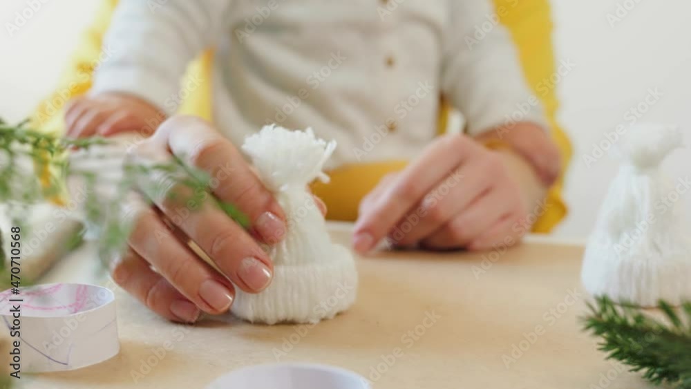A young woman and her little child decorate a Christmas tree with a toy. Slow motion. Close up. A young woman and her little child decorate a Christmas tree with a toy. Slow motion. Close up.