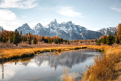 Teton mountain range reflection in the Snake River at Schwabacher's Landing in Grand Teton National Park, Wyoming. Fall scenic nature landscape with evergreen trees and a mountain water reflection.