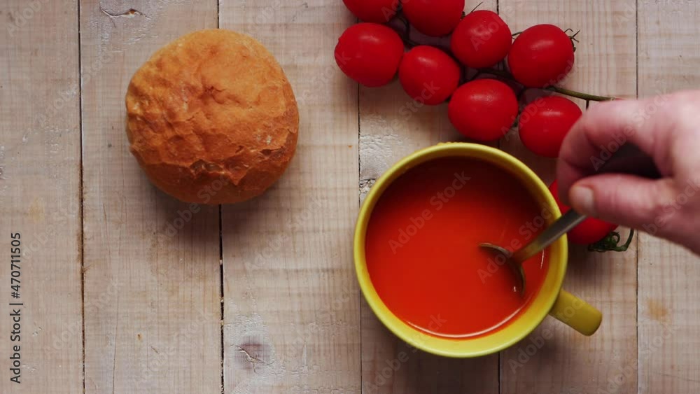 Stirring tomato soup with bread roll Stirring tomato soup with bread roll