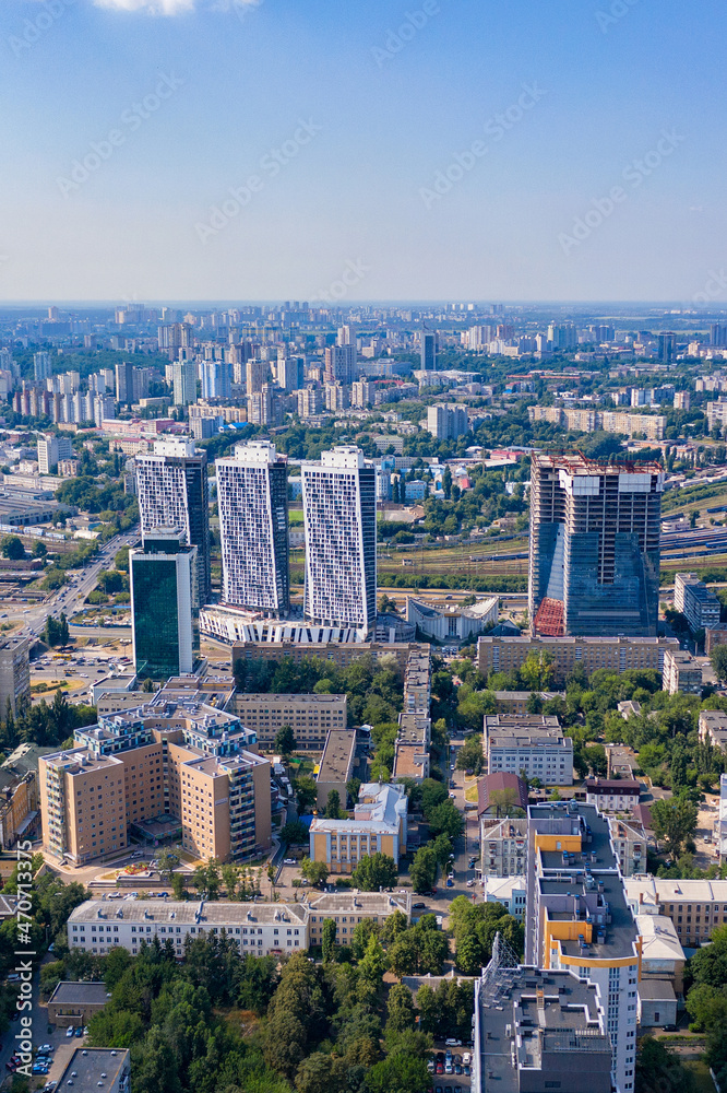 Fototapeta premium Aerial photography, urban residential areas and green parks in the summer blue haze and sunlight. Vertical image.