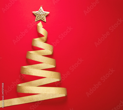 Fotografie Christmas tree shape golden ribbon on red background