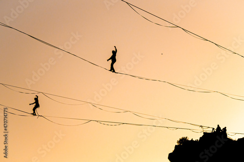 Slackliners durante una sessione di highline al tramonto in equilibrio durante la golden hour