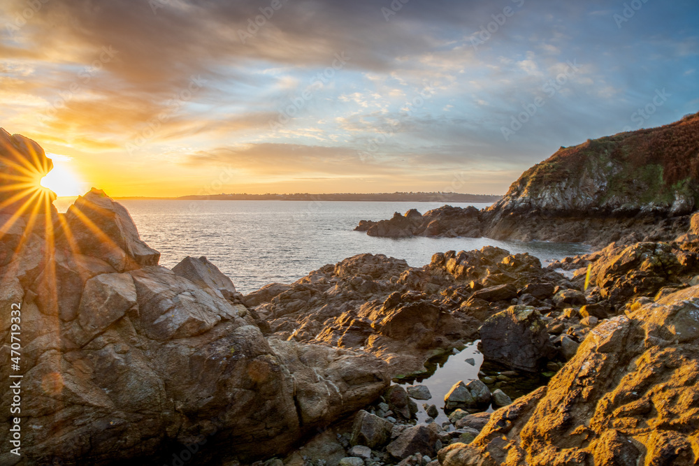 lever du jour étincelant sur la mer avec un beau ciel doré et des rochers en avant-plan  (Bretagne, France)