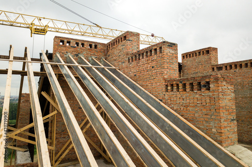 Unfinished brick apartment building with wooden roof structure under construction