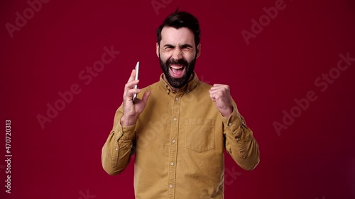 the peasant received a call and was told good news, he immediately had a positive mood, he is bearded, black-haired, dressed in a brown shirt, the background is red