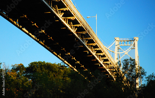 Billede på lærred A long suspension bridge spans a river at Kingston, New York