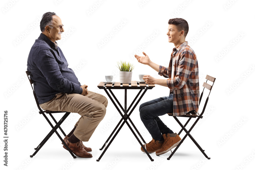 Obraz premium Young man talking to a mature man and sitting in a cafe