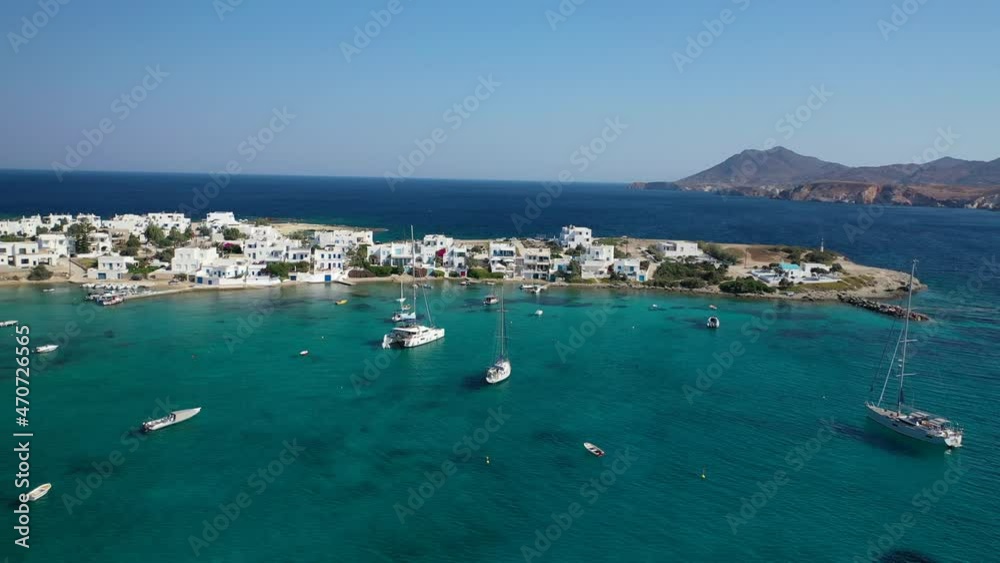 Aerial drone rotational video of picturesque fishing village of Polonia with traditional fishing boats anchored next to island of Kimolos, Milos island, Cyclades, Greece Aerial drone rotational video of picturesque fishing village of Polonia with traditional fishing boats anchored next to island of Kimolos, Milos island, Cyclades, Greece