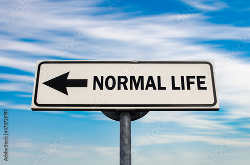 Normal life road sign, arrow on blue sky background. One way road sign. Arrow on a pole pointing in one direction.