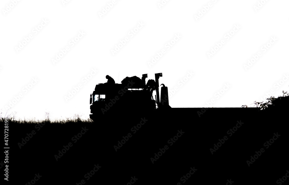 Fototapeta premium Silhouette of a British army soldier navigating from the cabin roof of a MAN SV 8x8 EPLS truck on a military exercise, Wiltshire UK 