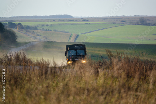 British army MAN SV 4x4 driving a dusty stone track on a military exercise, Wiltshire UK