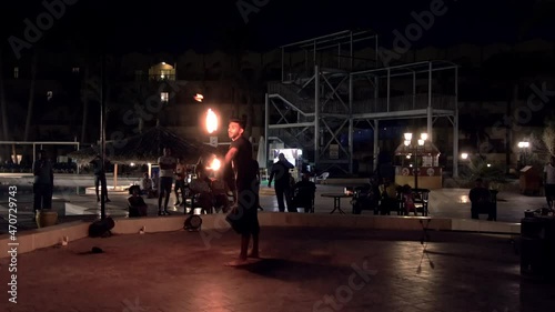 Hurghada, Egyptt - 20 May, 2021: Fire preformance of artists juggling with burning poi's at fire performance photo
