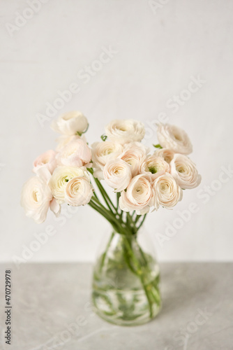 Spring background, flower Wallpaper. Persian buttercup. Bunch pink ranunculus flowers on light gray background. Vase on vintage wooden table. Wallpaper