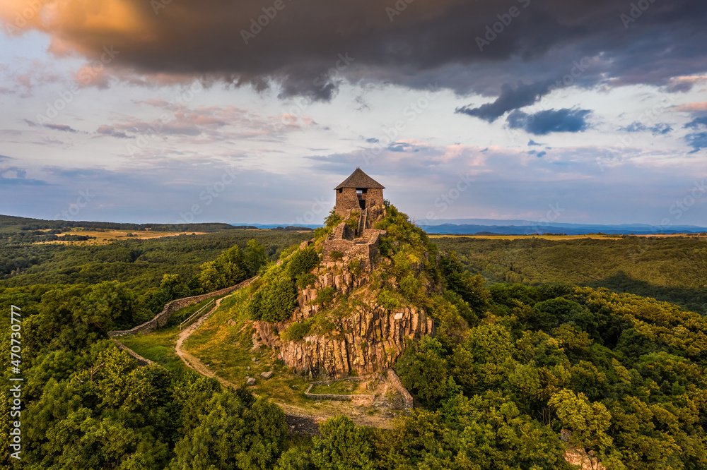 Salgotarjan, Hungary - Aerial view of the ruins of Salgo Castle (Salgo vara) in Nograd county with dark storm clouds above at sunset on a sunny summer afternoon