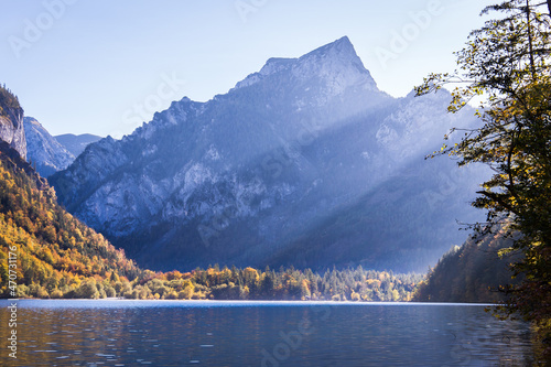 landscape with lake and mountains. Rays of sun visible coming from behind a mountain