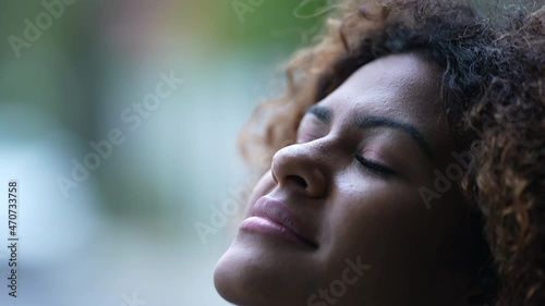 African woman close-up face looking at sky smiling in contemplation photo