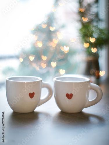 Couple valentines coffee mug with red color mini heart. Cozy atmosphere with lighting heart bokeh in background with copy space, romantic couple and happy valentine concept