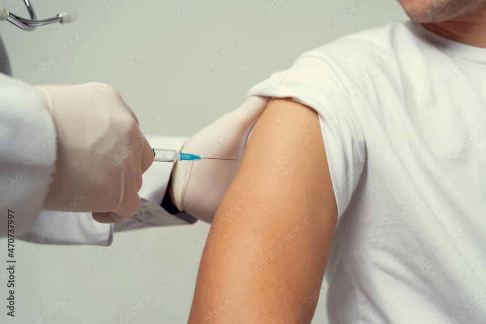 Injection syringe vaccination against the epidemic, in the clinic. Doctor of Medical Sciences professor vaccination against the virus. Injection syringe vaccination against the epidemic, in the clinic. Doctor of Medical Sciences professor vaccination against the virus.