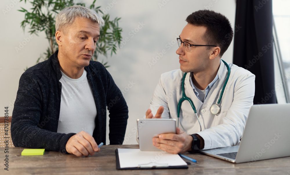 Consultation visit to a medical office. Male client at the clinic. The doctor communicates with patients in his office. Consultation visit to a medical office. Male client at the clinic. The doctor communicates with patients in his office.