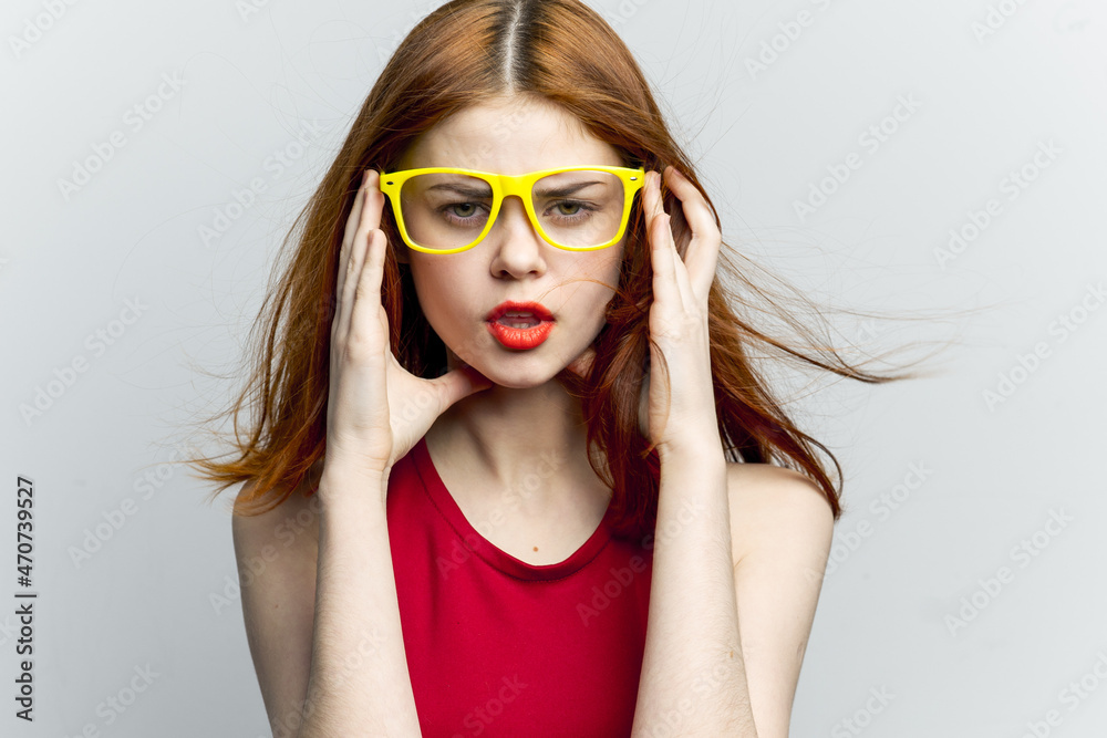 emotional woman in red dress yellow glasses posing