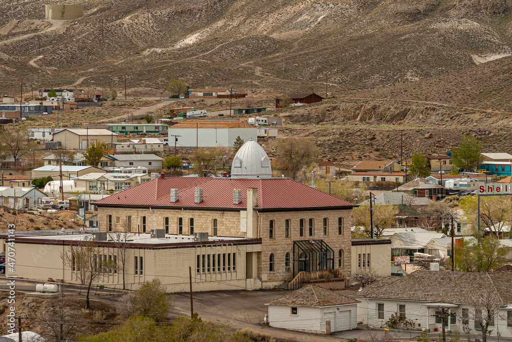 Tonopah, Nevada, US - May 18, 2011: Closeup of courthouse with small white dome set in neighborhood and brown mountain flank as backdrop.