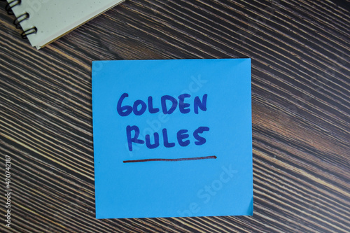 Golden Rules write on sticky notes isolated on Wooden Table.