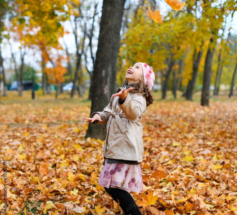 Girl playing with fallen yellow leaves. Portrait of a happy child in an autumn park. Girl playing with fallen yellow leaves. Portrait of a happy child in an autumn park.