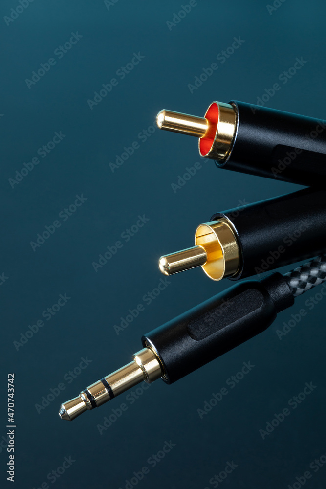 gold-plated RCA connectors and TRS connector for sound transmission, audio cable for excellent sound quality. Copy space, black background, gold-plated RCA connectors and TRS connector for sound transmission, audio cable for excellent sound quality. Copy space, black background,
