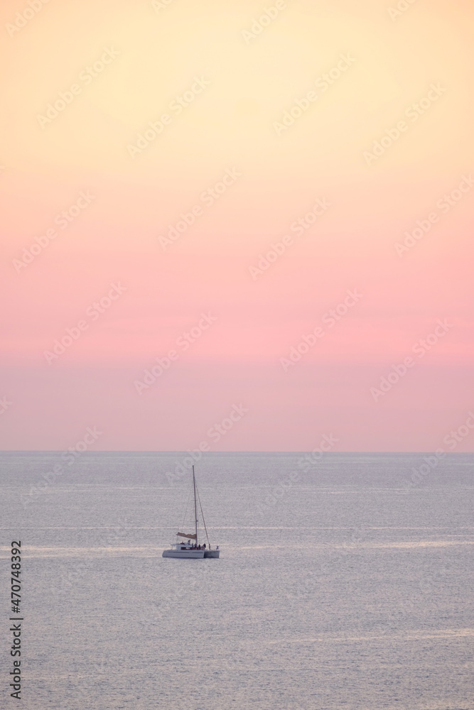 Seascape with a sailboat at sunset.