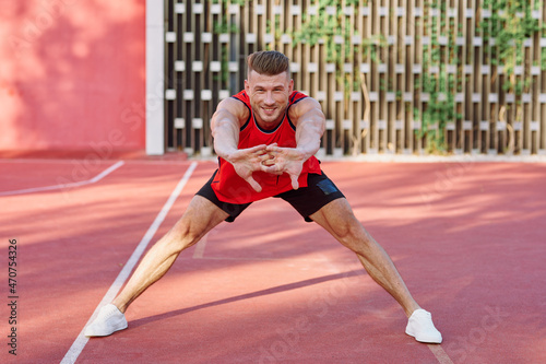 athletic man in red jersey on the sports ground exercise © VICHIZH