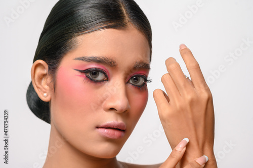 Pretty girl puts on pink makeup and puts her hand on the back of her hand.