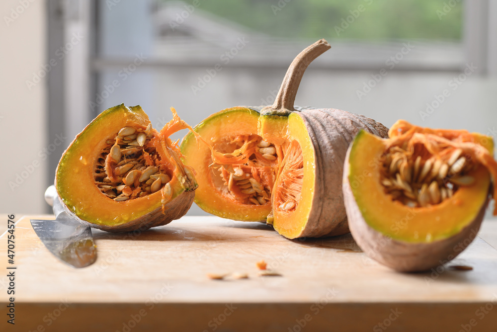 Sliced organic Asian pumpkin on wooden board prepared for cooking Sliced organic Asian pumpkin on wooden board prepared for cooking