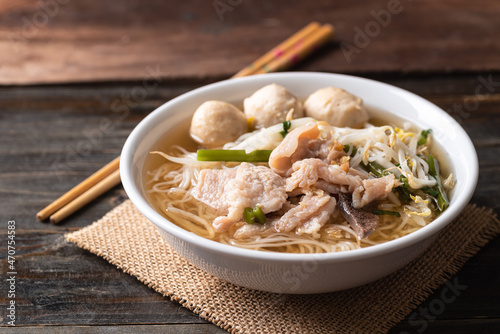 Rice noodles soup with pork and pork ball in a bowl on wooden background, Thai noodles soup