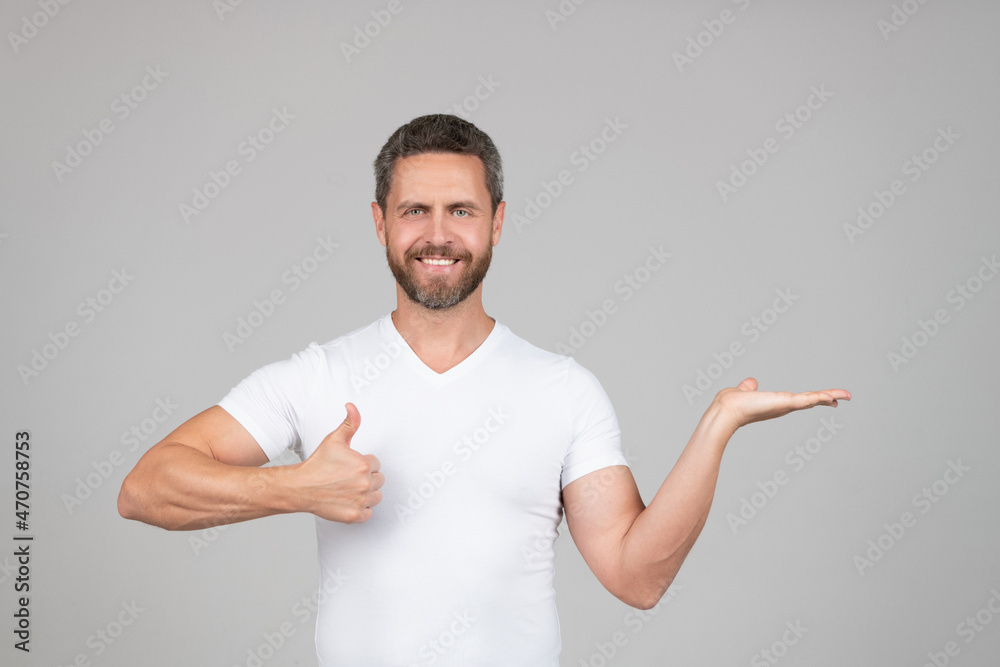 Presenting the best product. Happy man give thumbs-up showing open hand. Presenting product Presenting the best product. Happy man give thumbs-up showing open hand. Presenting product