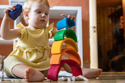 Картината върху платно Baby girl in dress stacking rainbow arch block construction building ecological